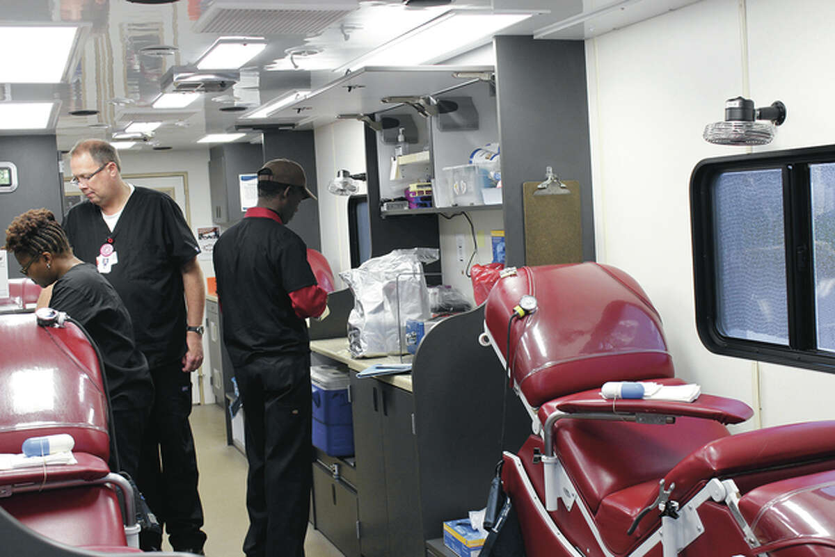 From left, Anika Barnes, Chip Smack and David Weatherspoon preparing for the donations inside the Mississippi Valley Regional Blood Center truck parked Saturday at Mungenast Alton Toyota.
