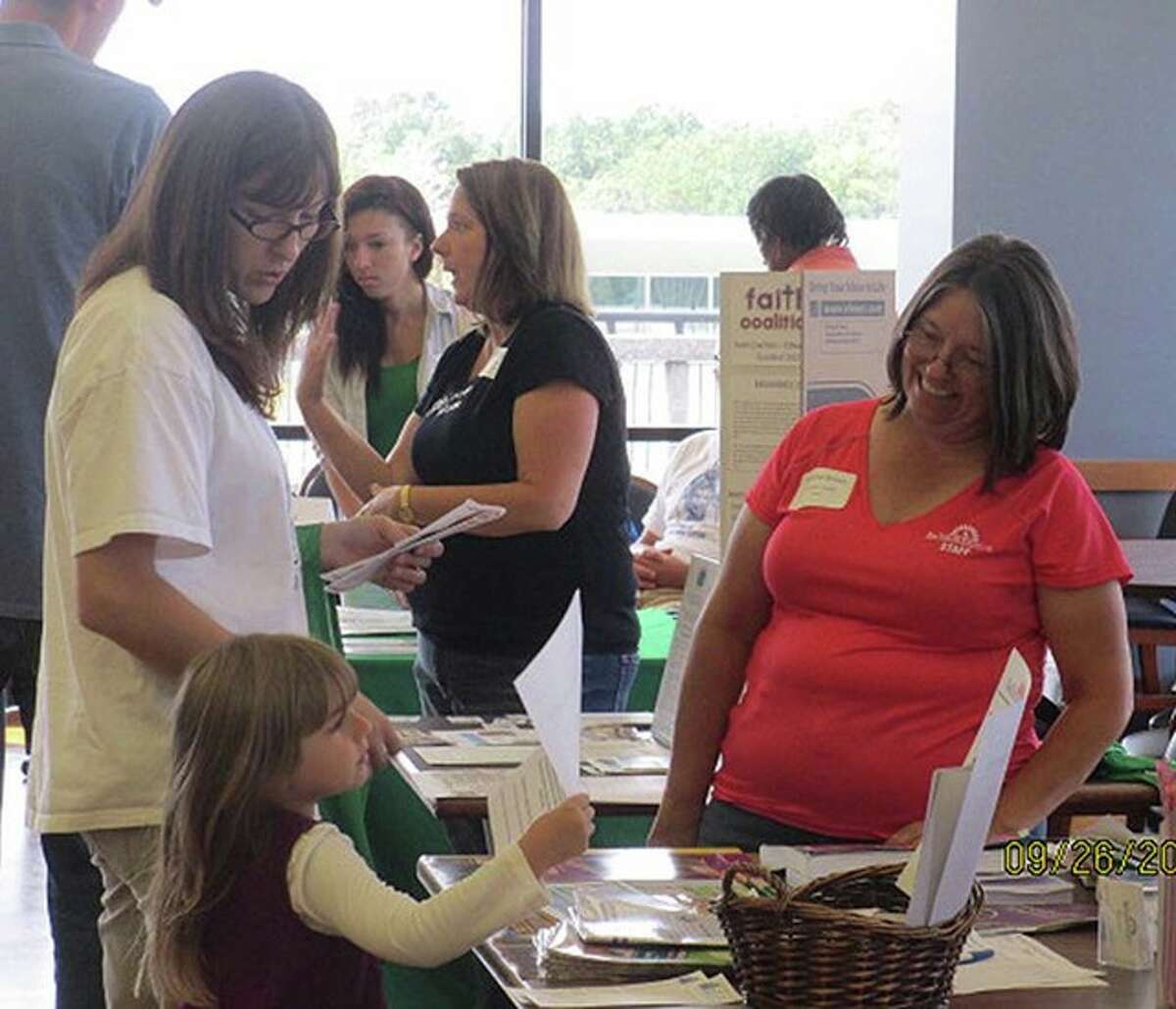 Patti Brown, right, representing the Nature Institute, shares information with a young student at the Madison County Green Schools Resource Fair on the campus of Southern Illinois University Edwardsville.