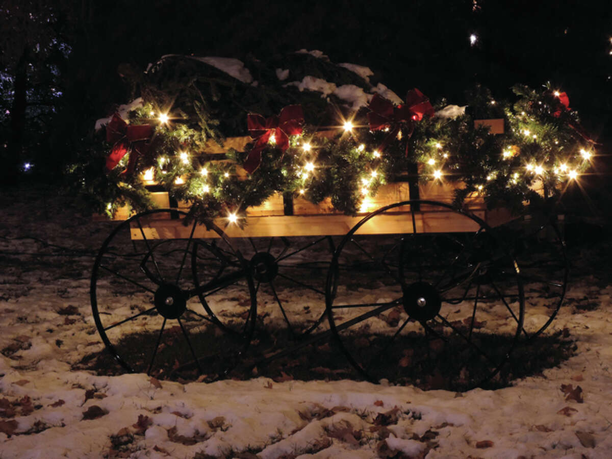 Christmas cart hold boughs of fir bedecked with ribbons and white lights.