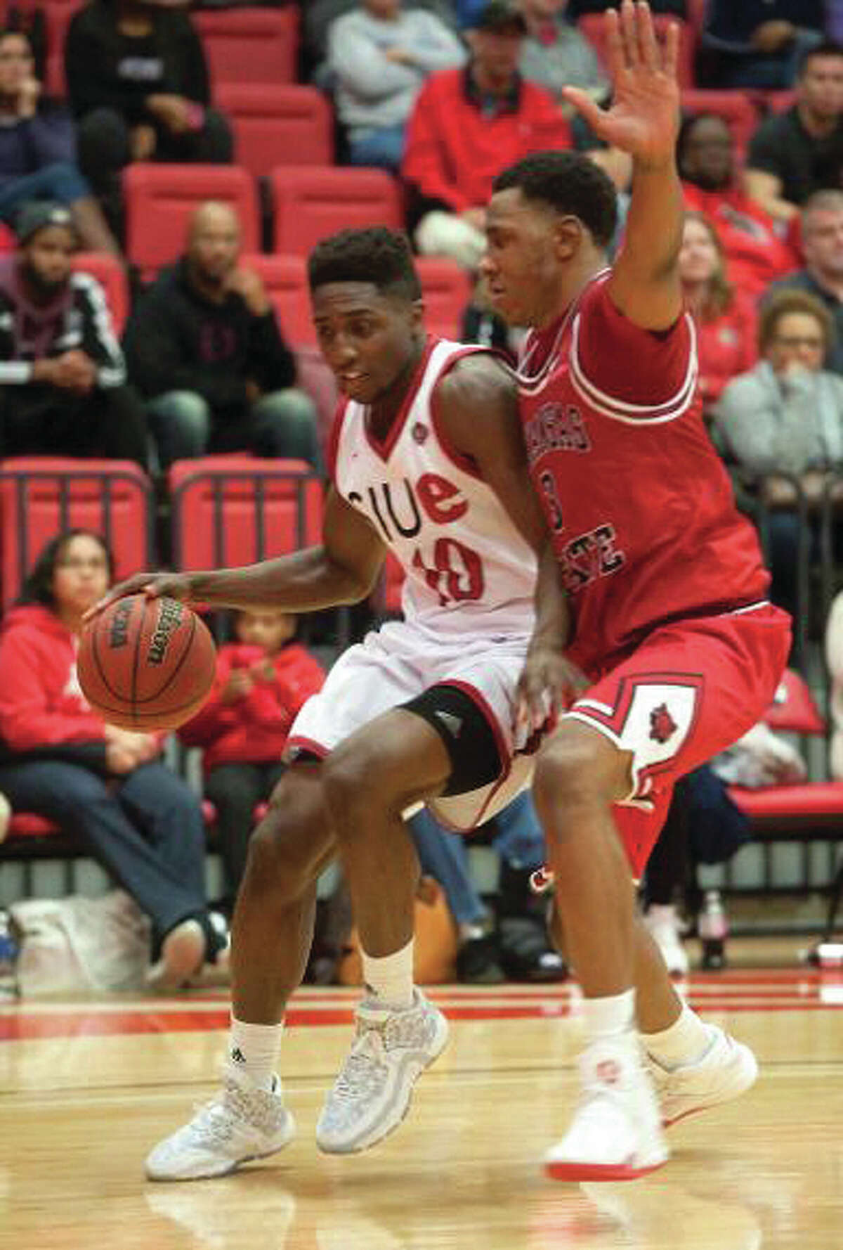 SIUE’s Carlos Anderson (left), a freshman from Alton, drives past an Arkansas State defender Friday night at Vadalabene Center in Edwardsville.