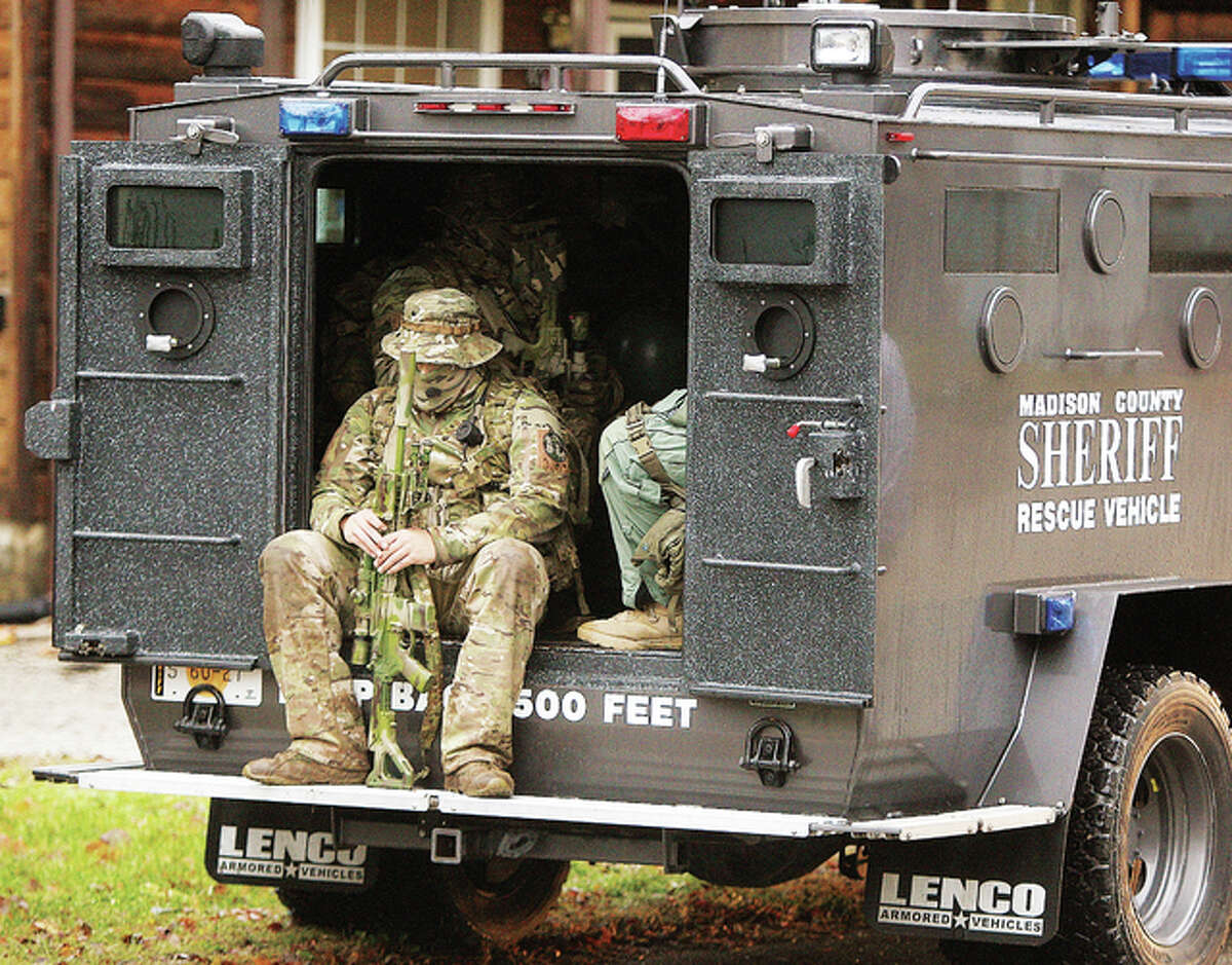 There was no shortage of firepower at the scene of an ILEAS tactical raid Tuesday morning in the 400 block of Jefferson Street in Alton. An officer sits in the rear of one of the ballistic vehicles, armed with a sniper’s rifle, as they prepare to leave the scene.