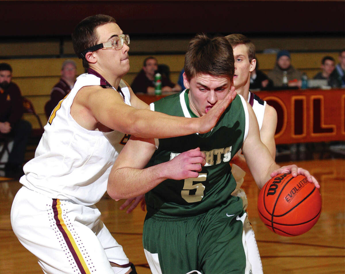 Metro East Lutheran’s Jason Johnson (right), shown driving on EA-WR’s Mike Stimac during a game last season in Wood River, was named MVP of the Metro East Lutheran Thanksgiving Turkey Tip-Off Classic on Saturday night after helping the Knights to the tourney championship.in Wood River.