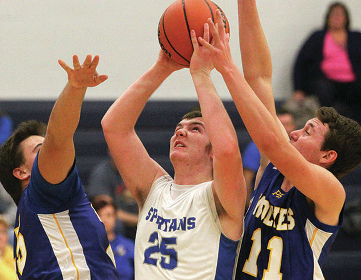 North Greene’s Chase Bushnell (center) puts up a shot between two Pleasant Hill defenders during the Spartans’ season-opening victory Tuesday night in White Hall.
