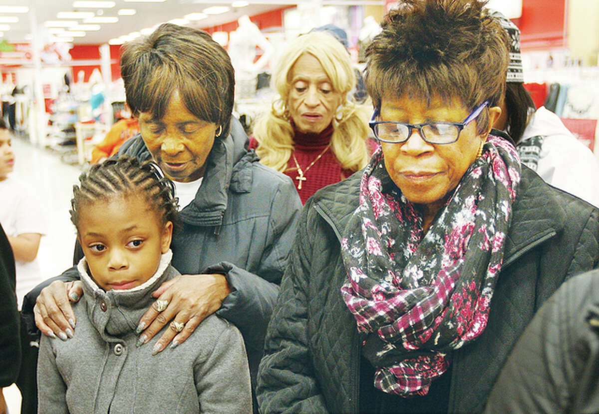 Some of the 42 children and their family members join in prayer before the start of the shopping spree Wednesday at the Alton Target store.