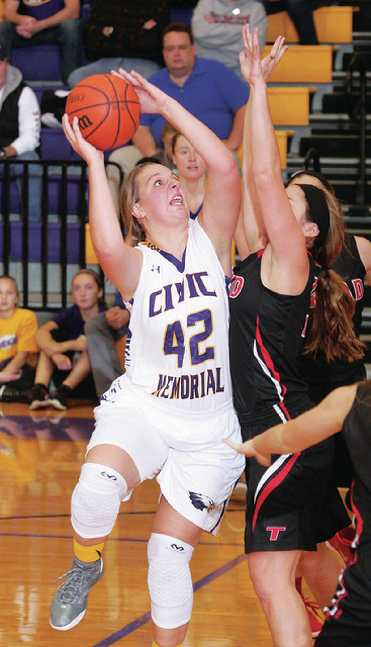 CM’s Izzy Buckley (42) turns and shoots over Triad’s Morgan Chigas for two points Monday night in Bethalto.