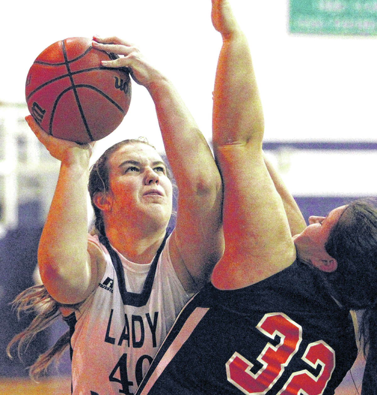 Greenfield’s Holly Jones (32) fouls Katie Abell of Jacksonville Routt Monday night in Jacksonville.