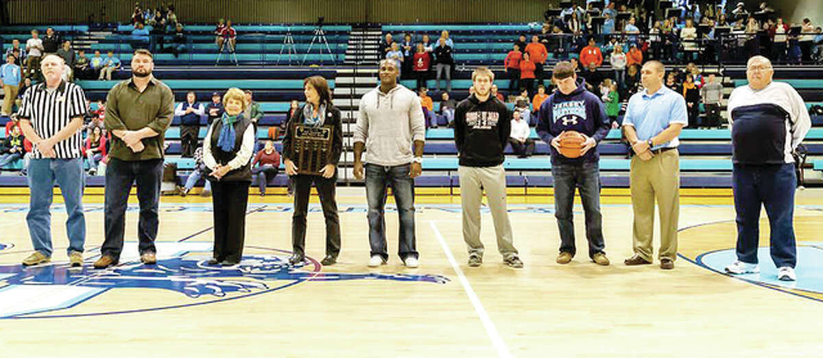 Recently, Jersey Community High School honored several of its 1,000-point basketball scorers who returned to welcome the 13th member of the JCHS 1,000 point club. Last season, Luke Shively made the final shot of his career in the regional championship game for his 1,000th career point and making him the latest member of the club. Shively finished his career as the school all-time leader in three-point field goals. Also honored was JCHS official scorer Mike Bridgewater, who is in his 40th season as the varsity team’s official scorer. From left: Mike Bridgewater, Derek Dunham, Ann Egehoff and Judy Egelhoff (wife and daughter of all-time leading scorer Rodger Egelhoff), Brent Hawkins, Kyle Steckel, Luke Shively and Ronnie McKinney.