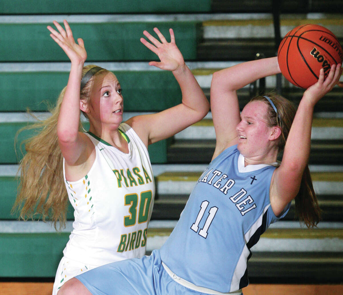 Southwestern’s Kelsey Rhoades (left) pressures Breese Mater Dei’s Kelsey Gerdes after Gerdes pulled down a defensive rebound during nonconference girls basketball action Saturday afternoon in Piasa.
