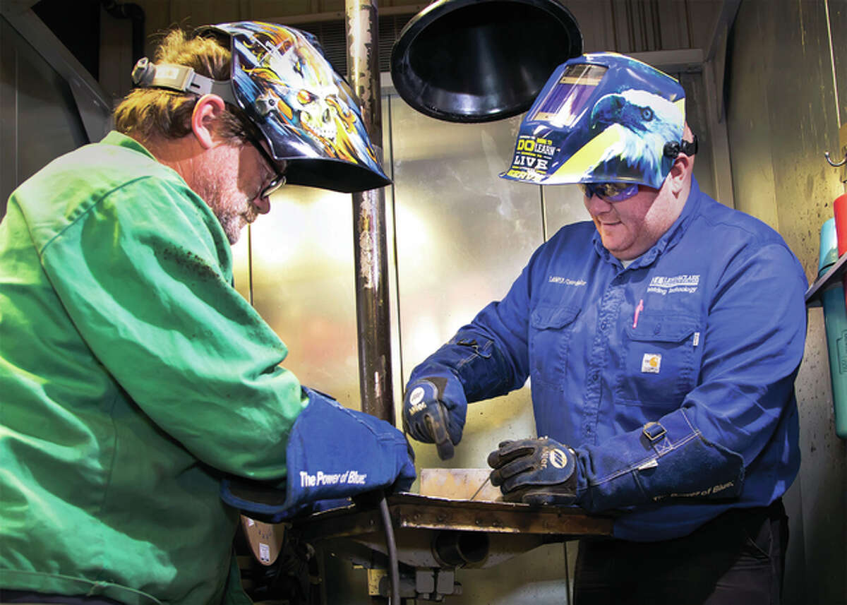 Travis Jumper, assistant professor and coordinator of Lewis and Clark Community College’s Welding program, right, instructs welding student Richard Frank, of Moro. Jumper received the 2015 Howard E. Adkins Memorial Instructor of the Year Award from the St. Louis section of the American Welding Society (AWS) in December. He started at LCCC in April 2012 and developed the welding program curriculum. He taught his first class during the second half of the fall 2012 semester and has seen interest and enrollment climb steadily in the field.