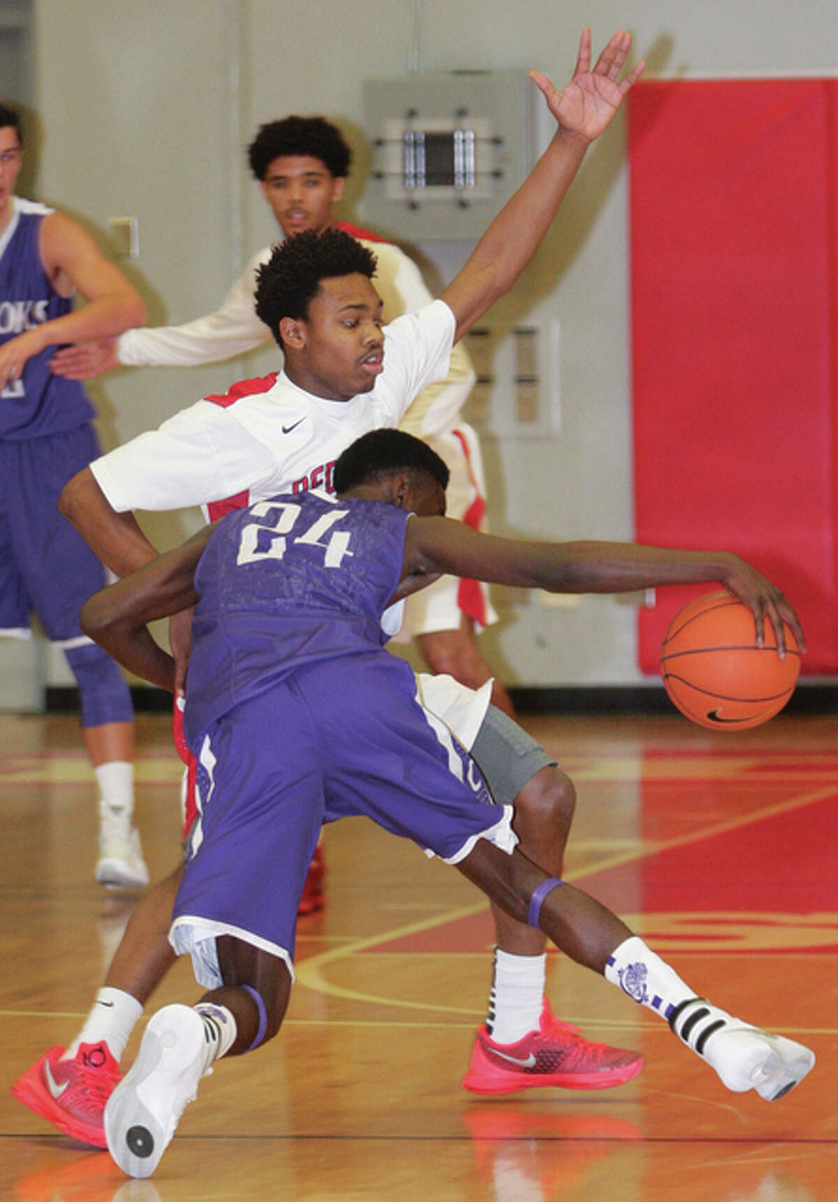 Alton’s Jordan Golley defends Collinsville’s Ronnie Midgett (24) on the perimeter during the Redbirds’ SWC victory Dec. 18 at Alton High. The 6-2 Redbirds hit the holidays unbeaten and tied for first in the Southwestern Conference race at 4-0.