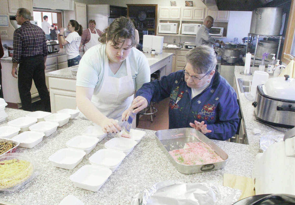 Tacoma Monroe, left, and Jo Carter prepare desserts for delivery Friday morning as part of the College Avenue Presbyterian Church’s annual Christmas dinner. The annual dinner was held at the United Presbyterian Church on Rock Hill Road in Wood River, where the College Avenue church is now co-located.