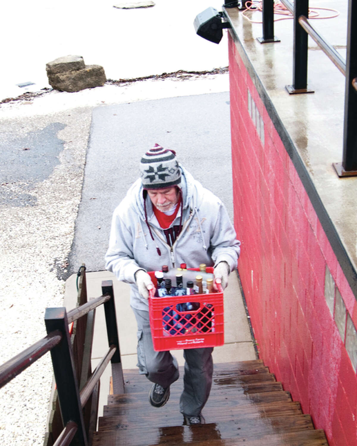 Greg Brummett brings crates to the top level of the Hawg Pit where river water is visibly creeping up on to the back of the entrance area.