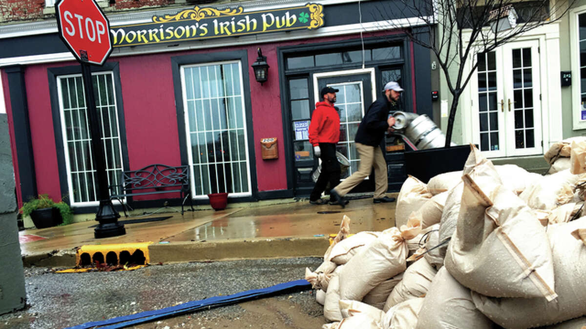 In Downtown Alton, two men move beer kegs out of Morrison’s Irish Pub, which was threatened by rising floodwaters Monday morning. Volunteers and employees of the restaurant and bar worked quickly to move out inventory and furniture.