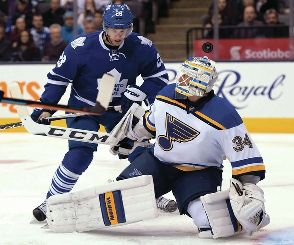 St. Louis Blues goaltender Jake Allen loses track of the puck over his head under pressure from Toronto Maple Leafs winger Brad Boyes (left) during the second period Saturday night in Toronto.