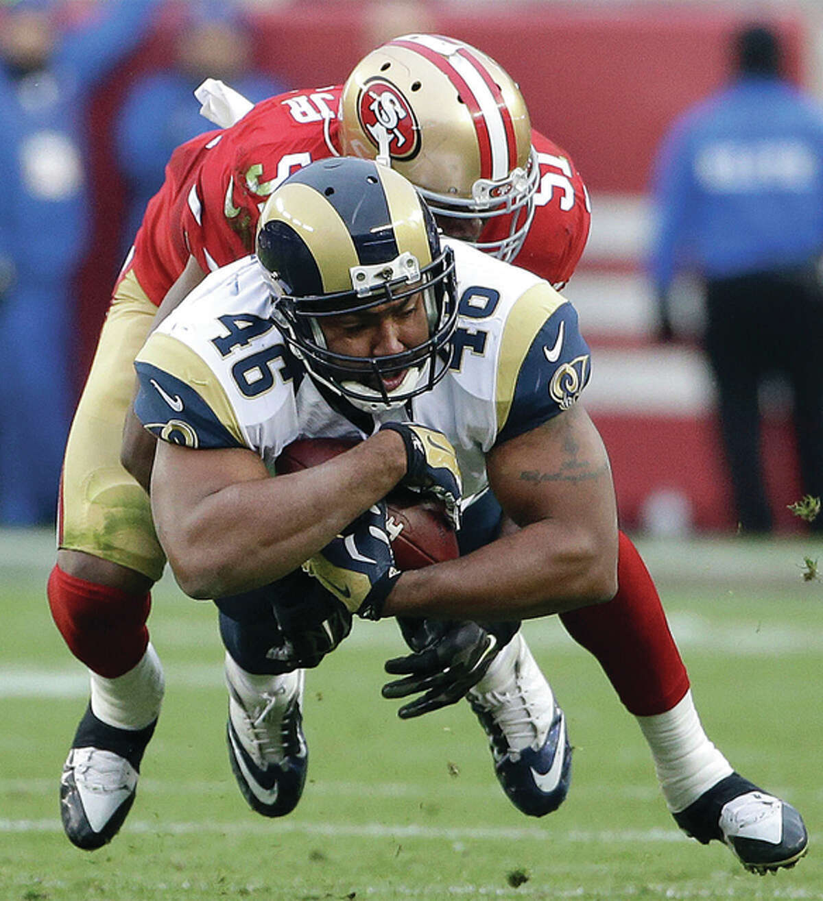 Rams tight end Cory Harkey (46) is tackled by 49ers linebacker Gerald Hodges during the second half Sunday in Santa Clara, Calif.