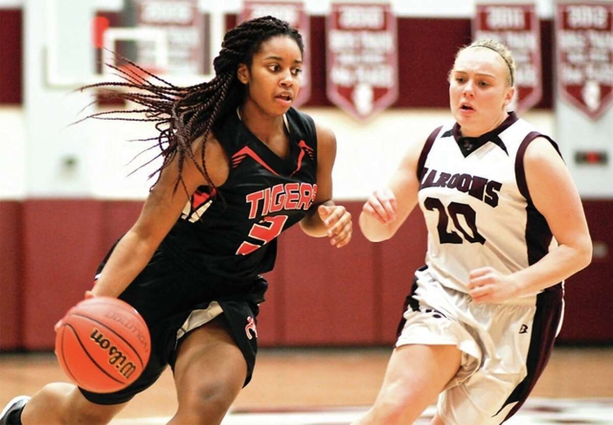 Edwardsville’s Aliyah Box, left, drives against Erika Harvey of Belleville West in earlier action. The 12-1 Tigers will play host to East St. Louis Tuesday.