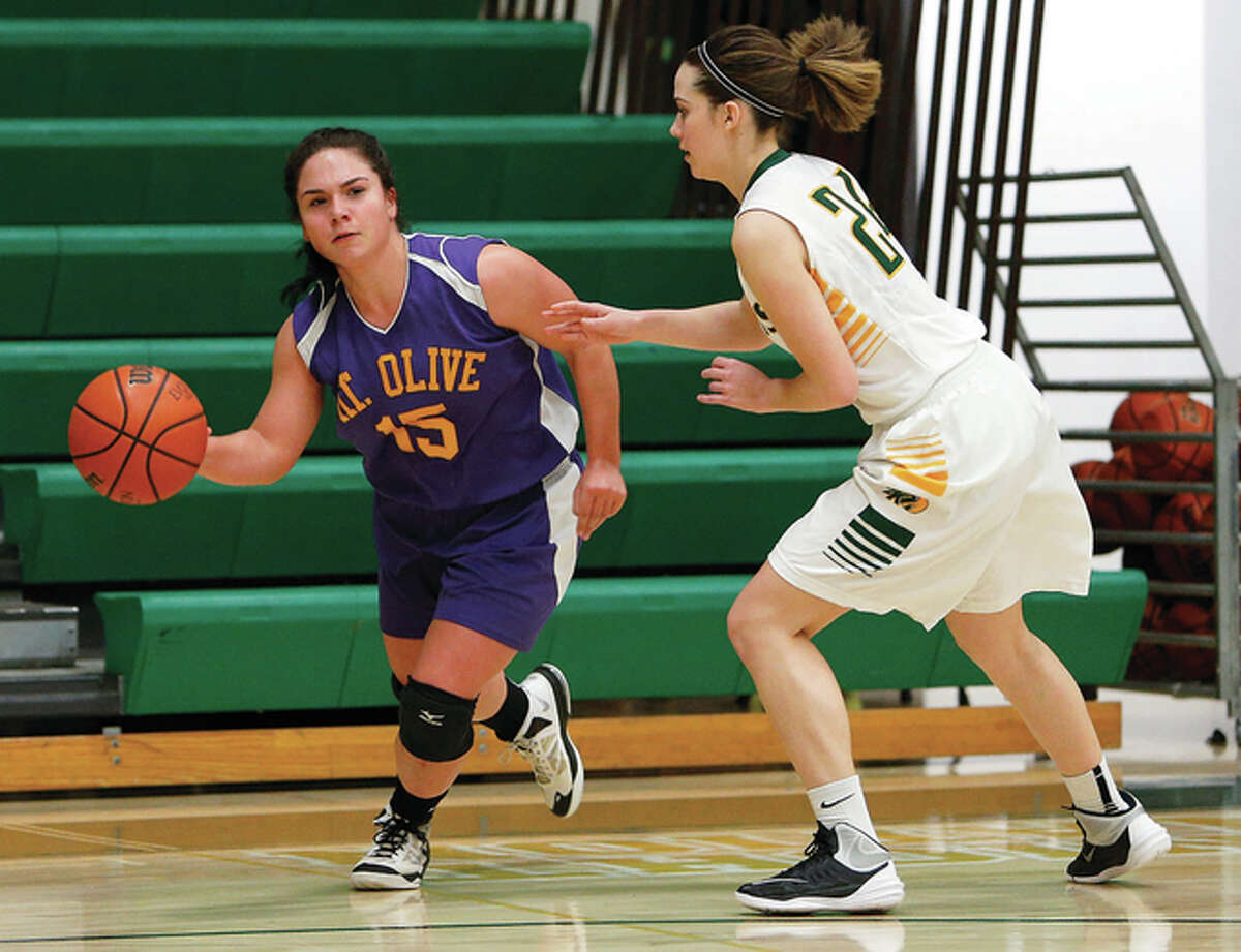 Mount Olive’s Caitlyn Fields (left) handles the ball while being defended by Metro East Lutheran’s Emma Eberhart during the Wildcats’ Prairie State Conference game Monday night at Hooks Gym in Edwardsville.