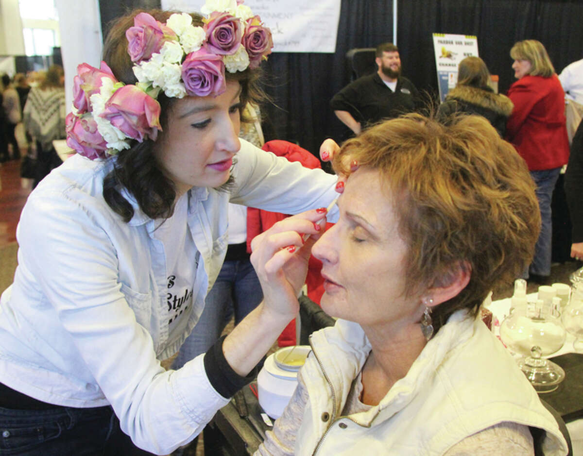 Stylist Connie Wilton, left, of PJ’s Cuts and Styles, does an eyebrow wax on Linda Joyce, of Godfrey, at the Telegraph’s Annual Bridal Show, held Sunday at The Commons at Lewis and Clark Community College. More than 40 vendors showed off everything from wedding cakes to wedding dresses.