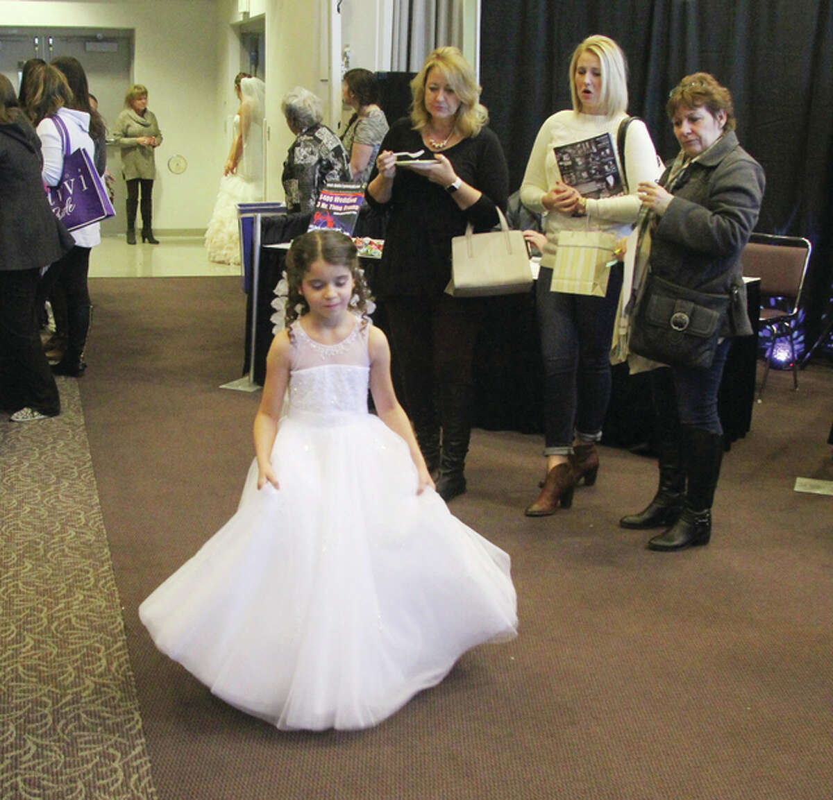 Model McKenna Fox walks through the crowds to get to the stage during one of two fashion shows at The Telegraph’s Annual Bridal Show, held Sunday at The Commons at Lewis and Clark Community College.