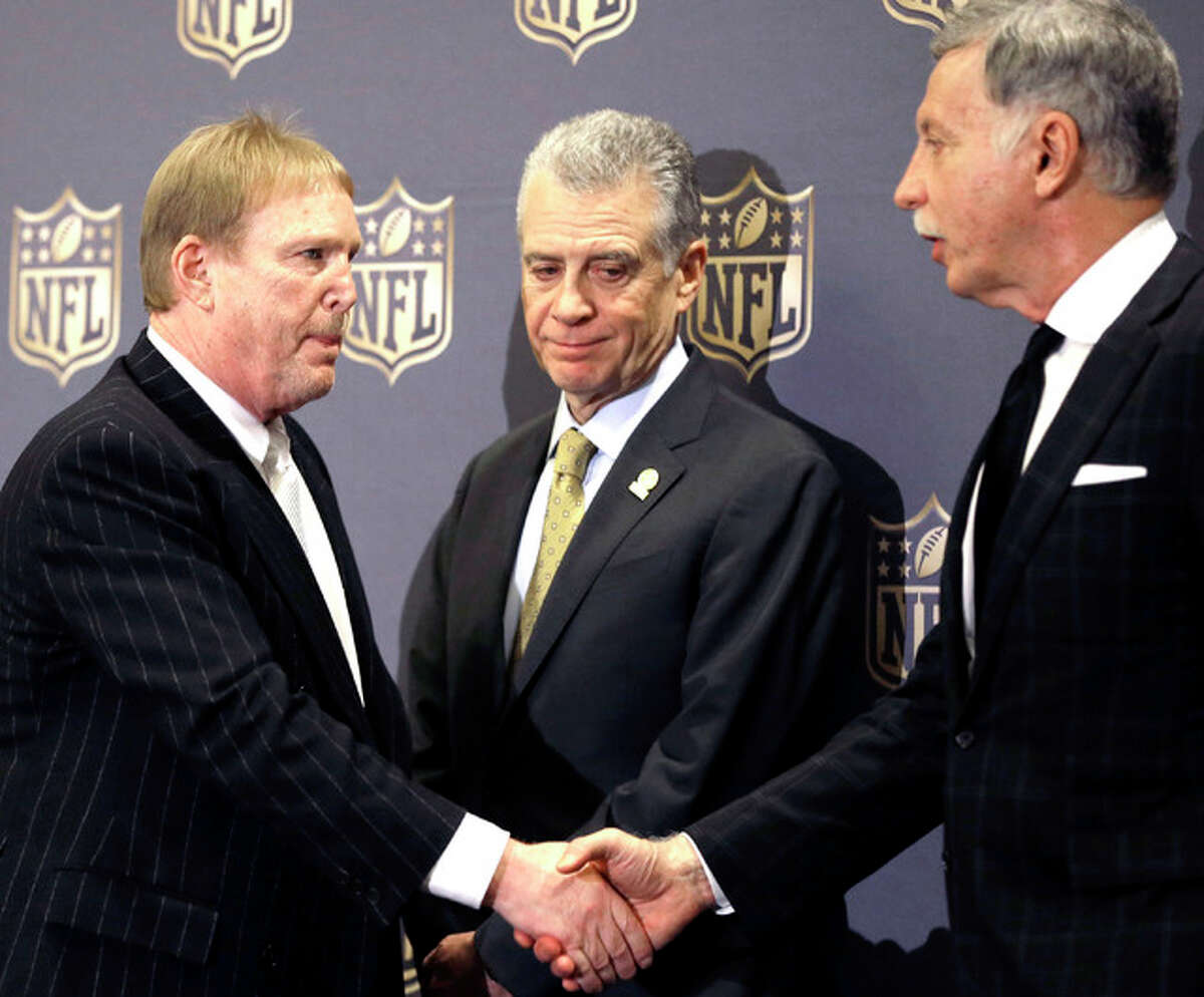 Oakland Raiders owner Mark Davis, left, shakes hands with Rams owner Stan Kroenke, right, as Pittsburgh Steelers president Art Rooney II looks on after an NFL owners meeting Tuesday, Jan. 12, 2016, in Houston. The owners voted to allow the Rams to move to a new stadium just outside Los Angeles, and the San Diego Chargers will have an option to share the facility.
