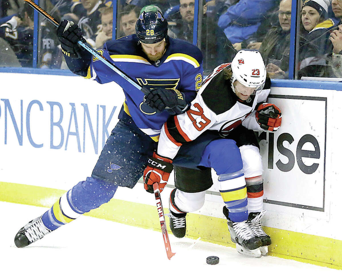 The Blues’ Kyle Brodziak, left, and New Jersey Devils’ Bobby Farnham chase after a loose puck Tuesday in St. Louis. The Blues won 5-2.