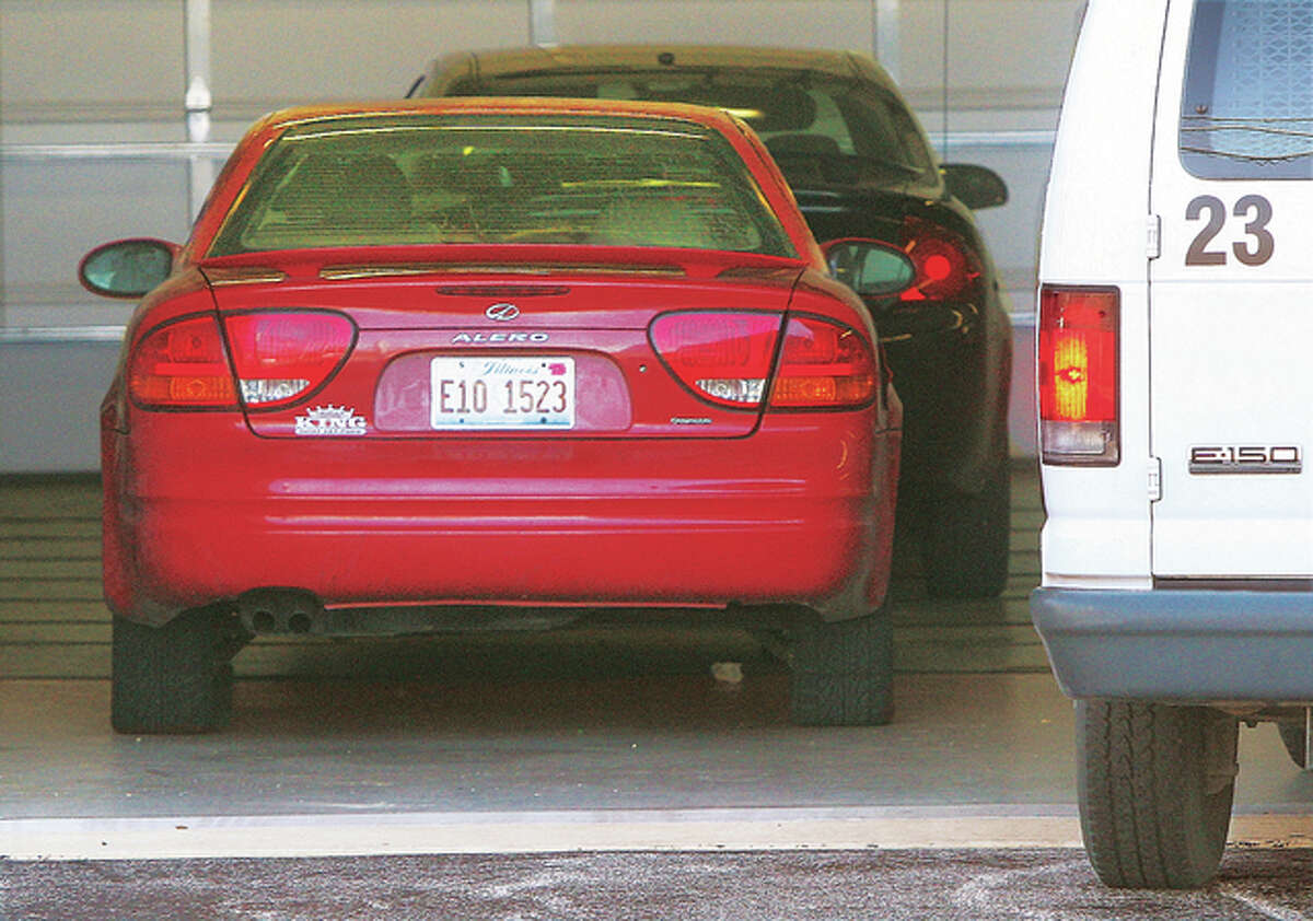 A red Oldsmobile Alero sits in the prisoner unloading bay at the Alton Law Enforcement Center Thursday. Alton police confirmed they recovered the red car, which was used in the killing of 11-year-old Romell Jones. The bay is where police take evidence vehicles for processing. An 18-year-old has been charged in connection with the killing.