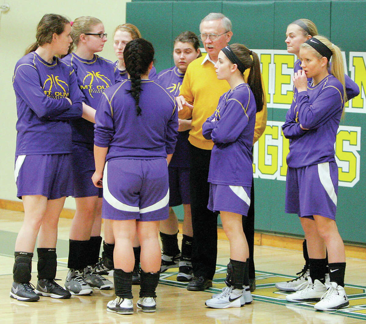 Mount Olive coach Dave Kernich (middle) meets with eight-girl Wildcats team before a game Jan. 4 at Metro East Lutheran in Edwardsville. The 18-3 Cats clinched their first-ever conference championship Thursday at Marquette.