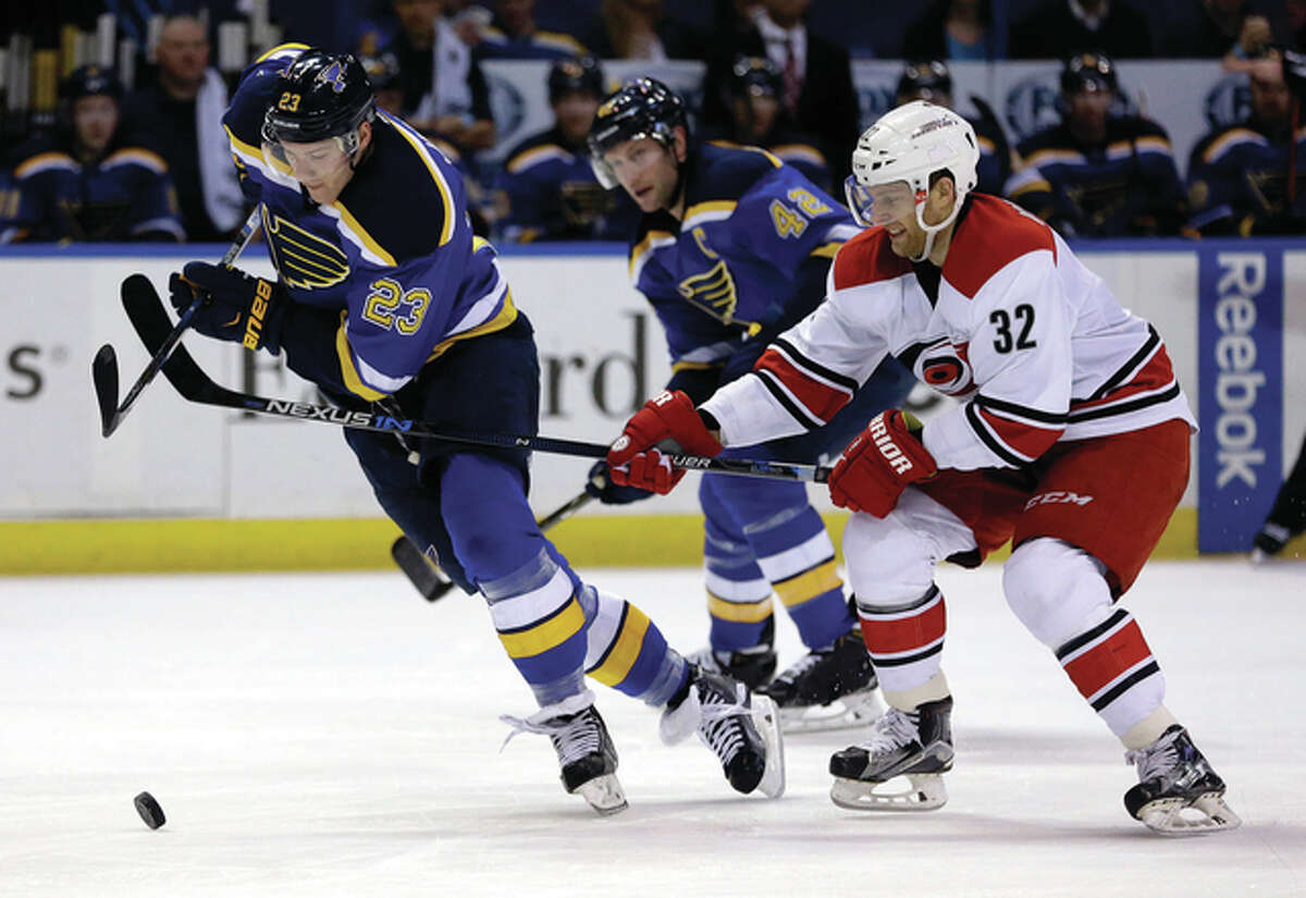 The Blues’ Dmitrij Jaskin (left) and Carolina’s Kris Versteeg (32) chase after the puck as Blues’ David Backes (back) watches during the second period Thursday night in St. Louis.