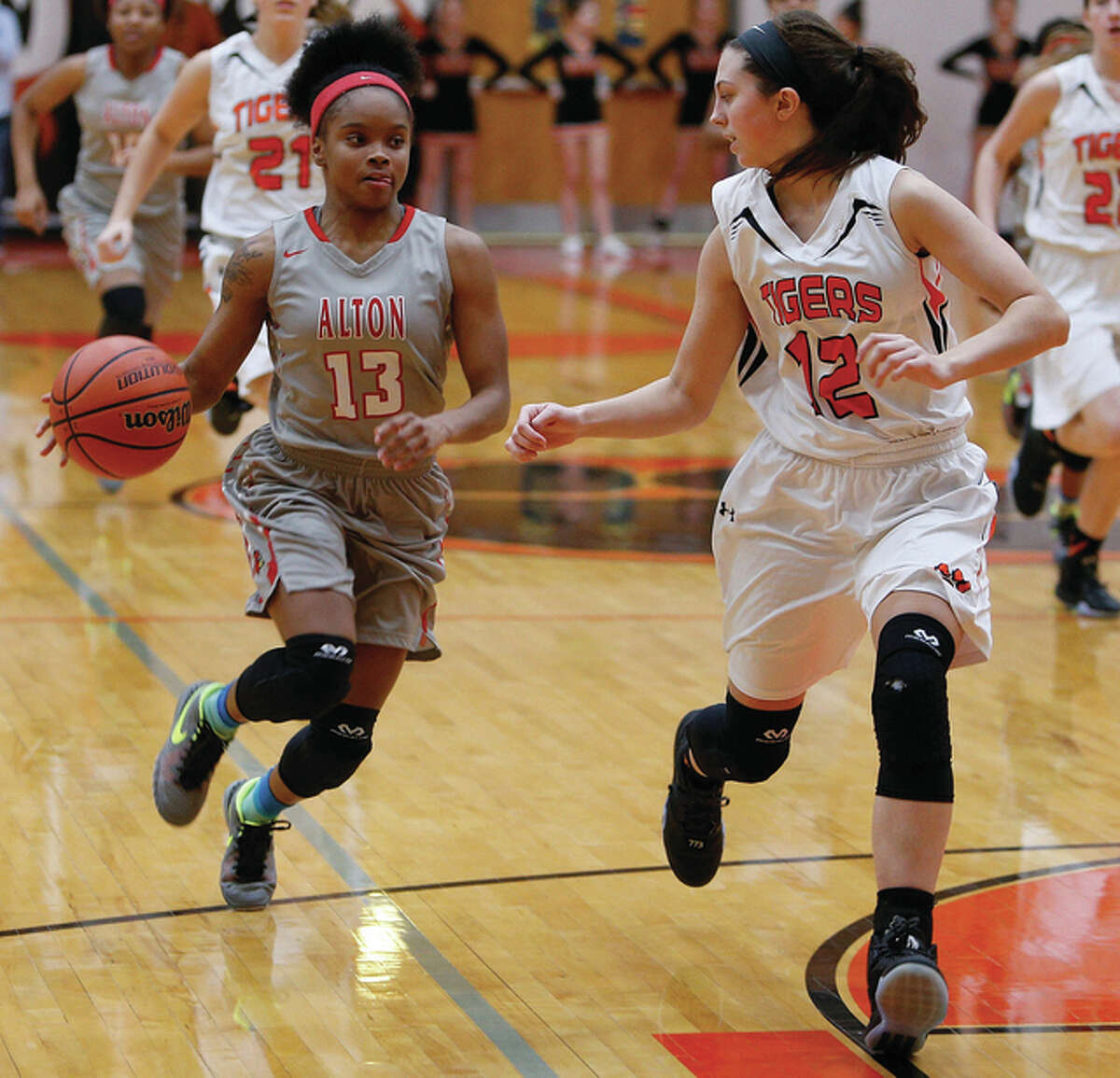 Alton’s LaJarvia Brown (left) drives to the basket while Edwardsville’s Makenzie Silvey defends during Friday night’s Southwestern Conference girls basketball game at Lucco-Jackson Gym in Edwardsville.