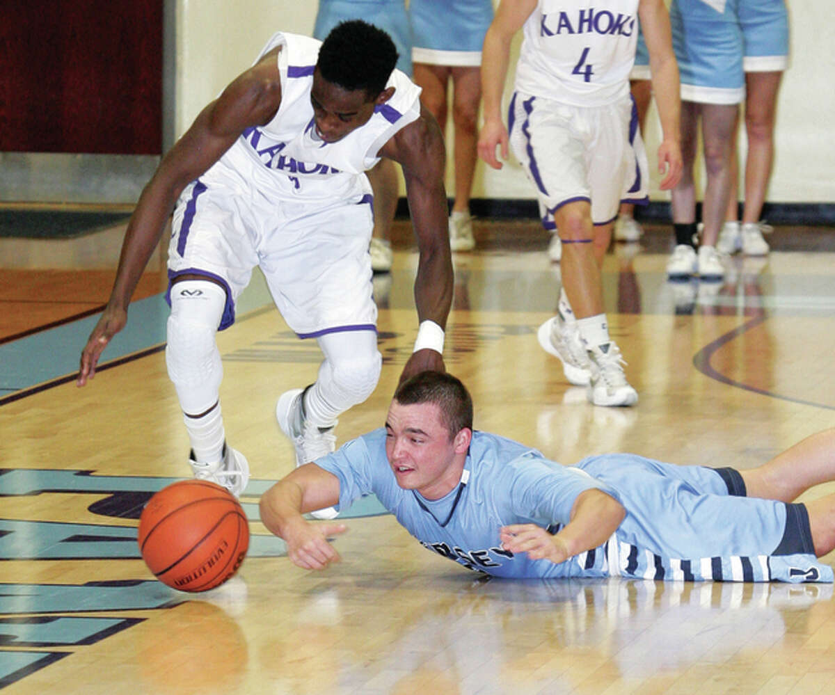 Jersey’s Jacob Witt (front) dives to beat Collinsville’s Ronnie Midgett (left) to a loose ball Monday night during the Jersey Mid-Winter Classic boys basketball tournament at Havens Gym in Jerseyville.