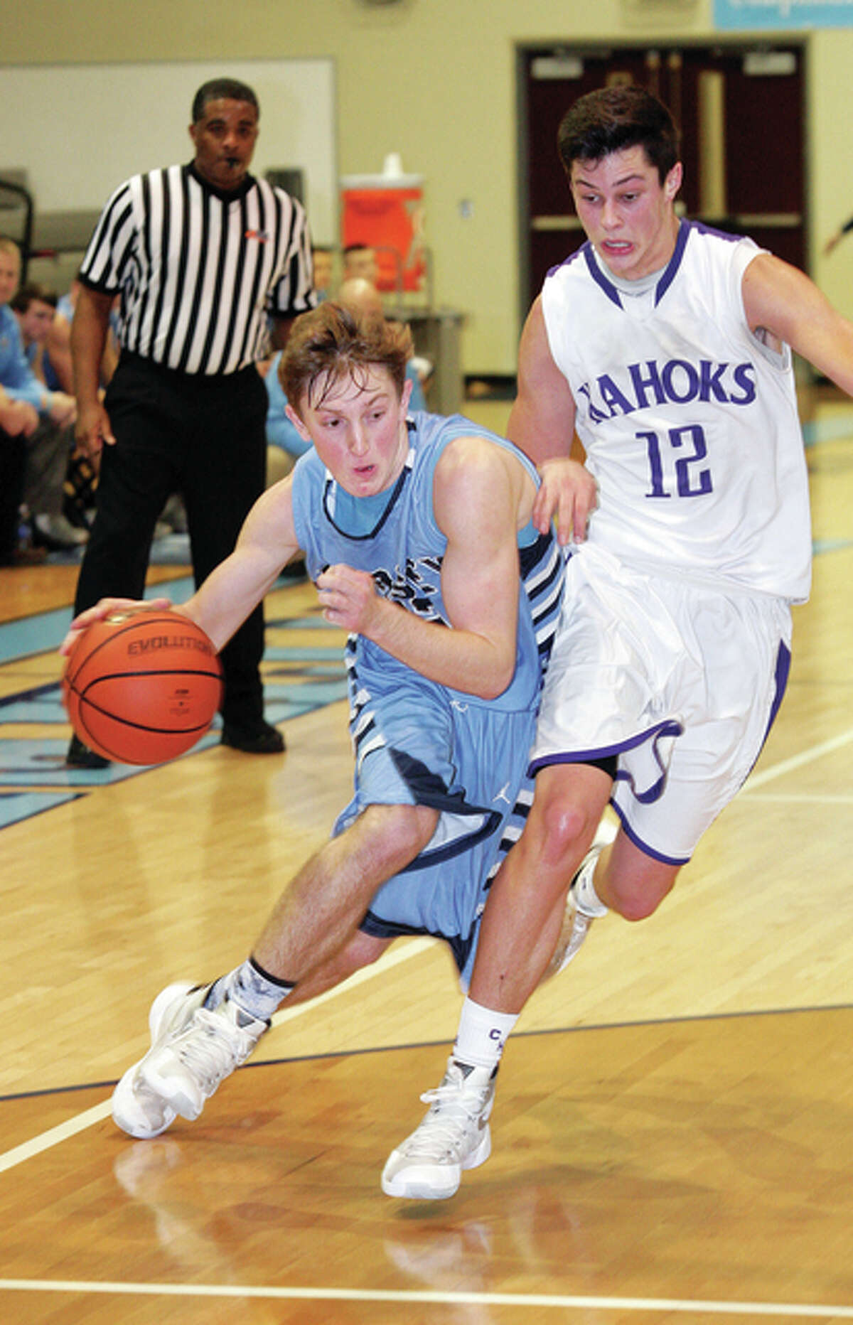 Jersey’s Zac Ridenhour (left) drives to the basket past Collinsville’s Zach Flora on Monday night at Havens Gym in Jerseyville.