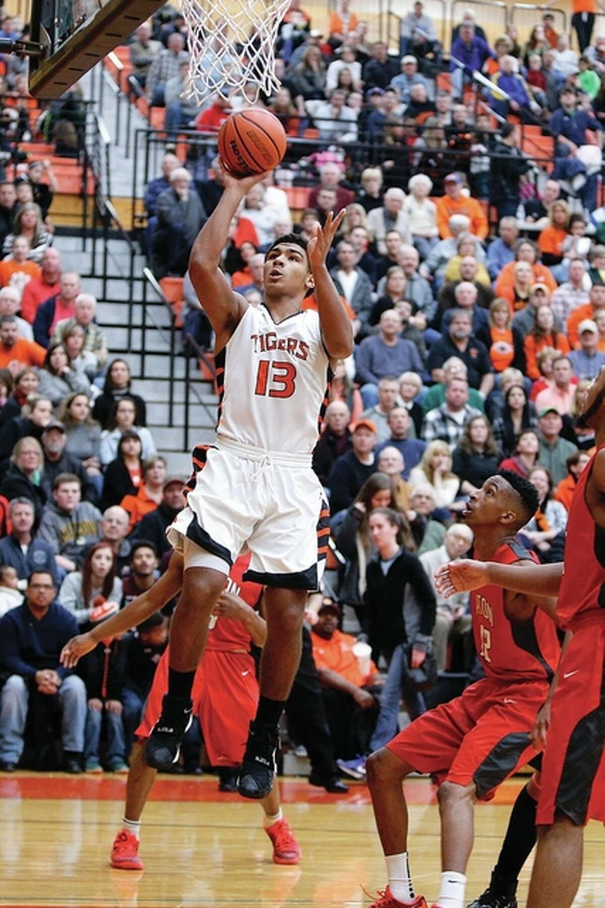 Edwardsville’s Mark Smith (13), shown going up for two points in a Tigers win over Alton on Jan. 15 in Edwardsville, had 29 points and 11 rebounds Friday night to lead his team to a semifinal victory at the Salem Tournament.