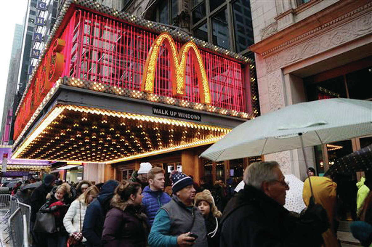 In this Tuesday, Dec. 29, 2015, photo, pedestrians pass under a McDonald’s marquee in New York. McDonald’s reports quarterly financial results as of Monday, Jan. 25, 2016.