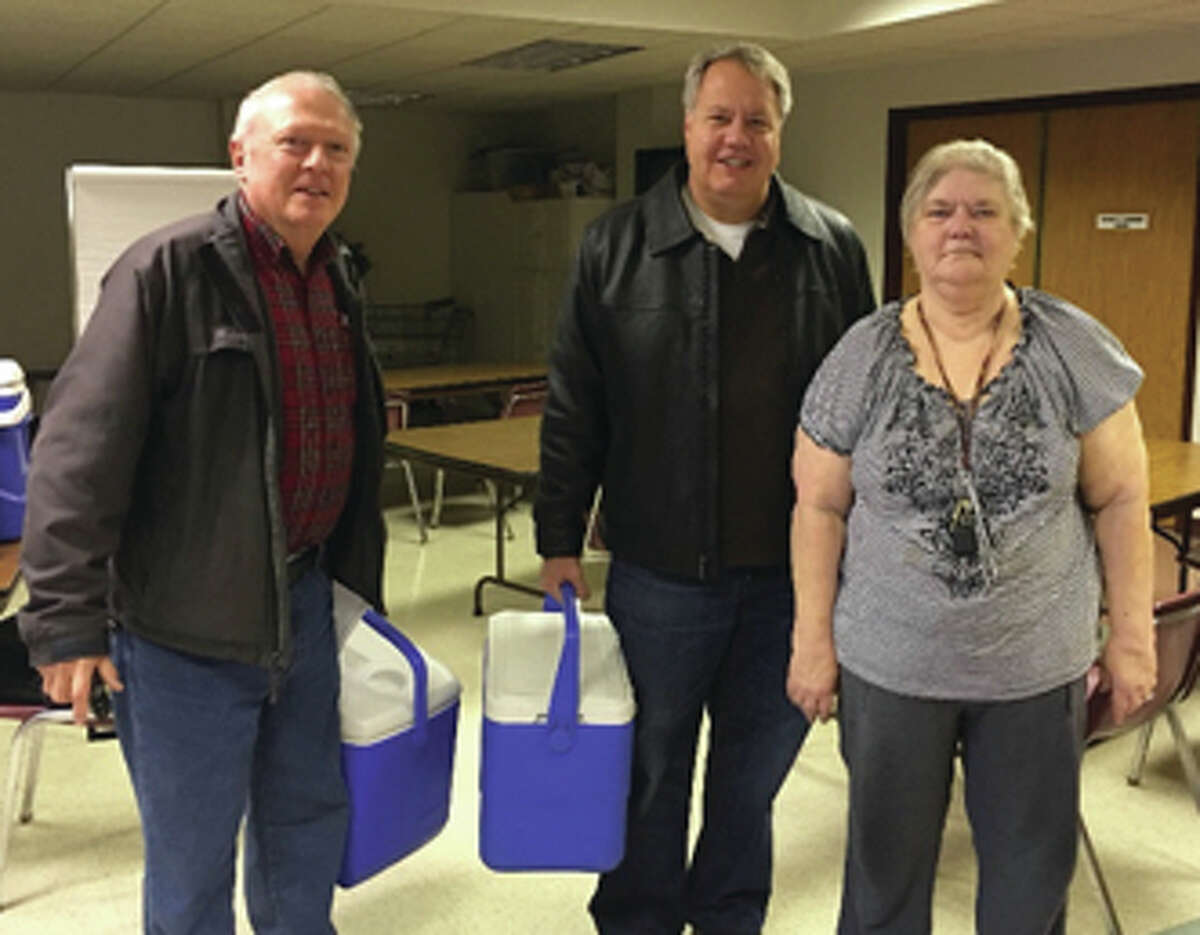 David Buckley,left, State Rep. Jay Hoffman, center, and Judy Denning prepare to load up the cars to deliver meals to local residents.