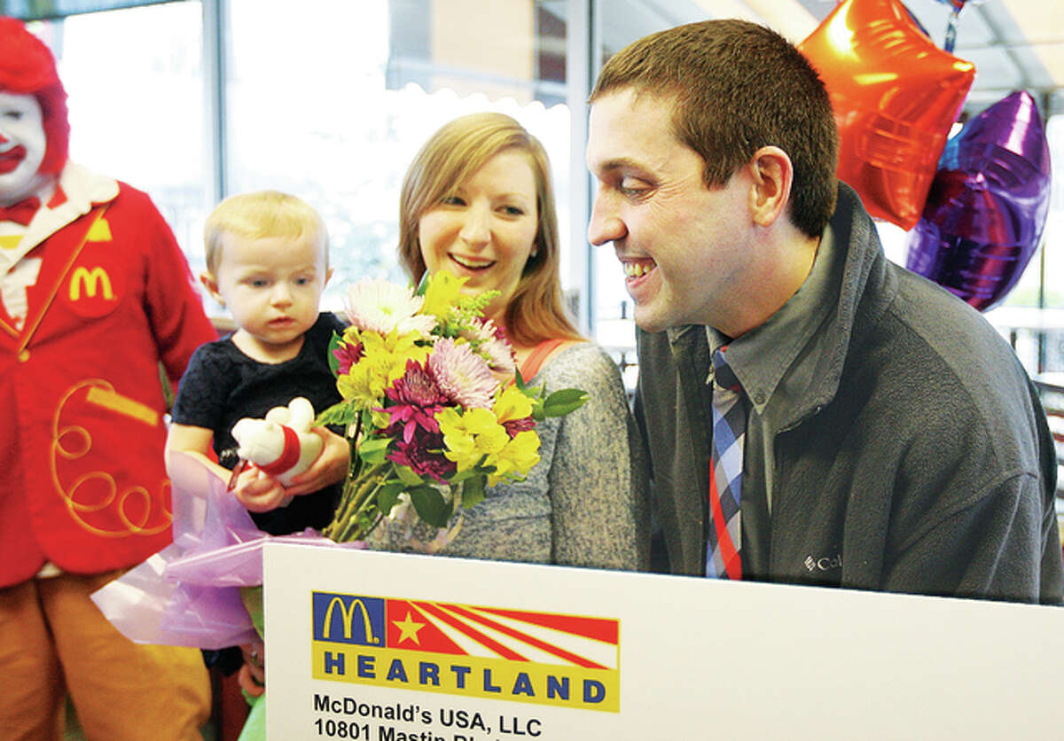Bethalto McDonald’s restaurant manager Mark Harlan, right, was all smiles Tuesday after he was awarded $2,500 and a trip to Disney World as part of receiving the prestigious Ray Kroc Award from the company. With him are his wife, Morgan, and their 14-month-old daughter, Laney, all of Alton.