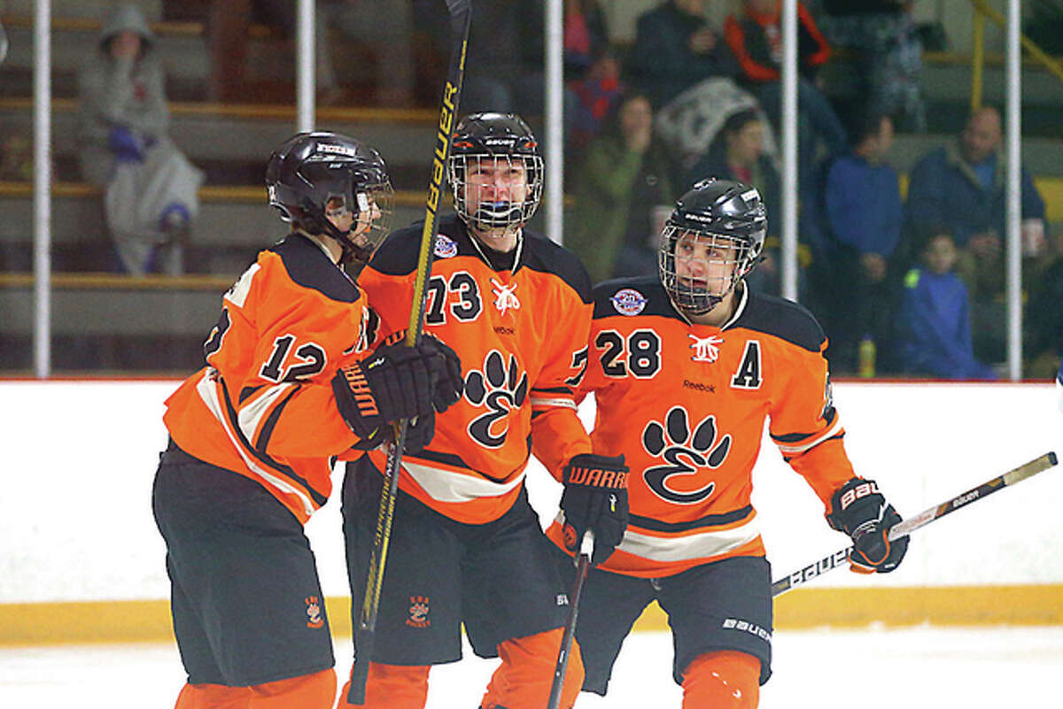 Edwardsville’s Lucas Tucker (73) celebrates with Stanley Lucas (12) and Rory Margherio (28) after scoring a goal against Columbia Tuesday night at the East Alton Ice Arena.