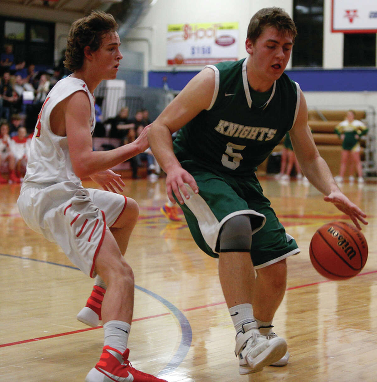 Roxana’s Zach Hess (left) defends while Metro East Lutheran’s Jason Johnson handles the ball on the perimeter Tuesday night in Roxana.