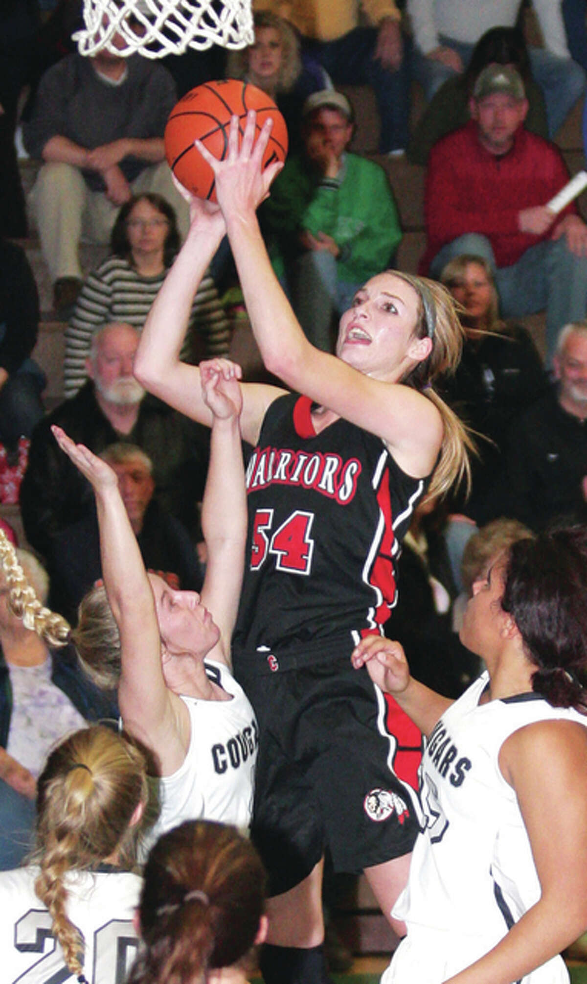 Calhoun’s Grace Baalman goes up and over the guard of West Central’s Sydney Rock Thursday night in Carrollton.