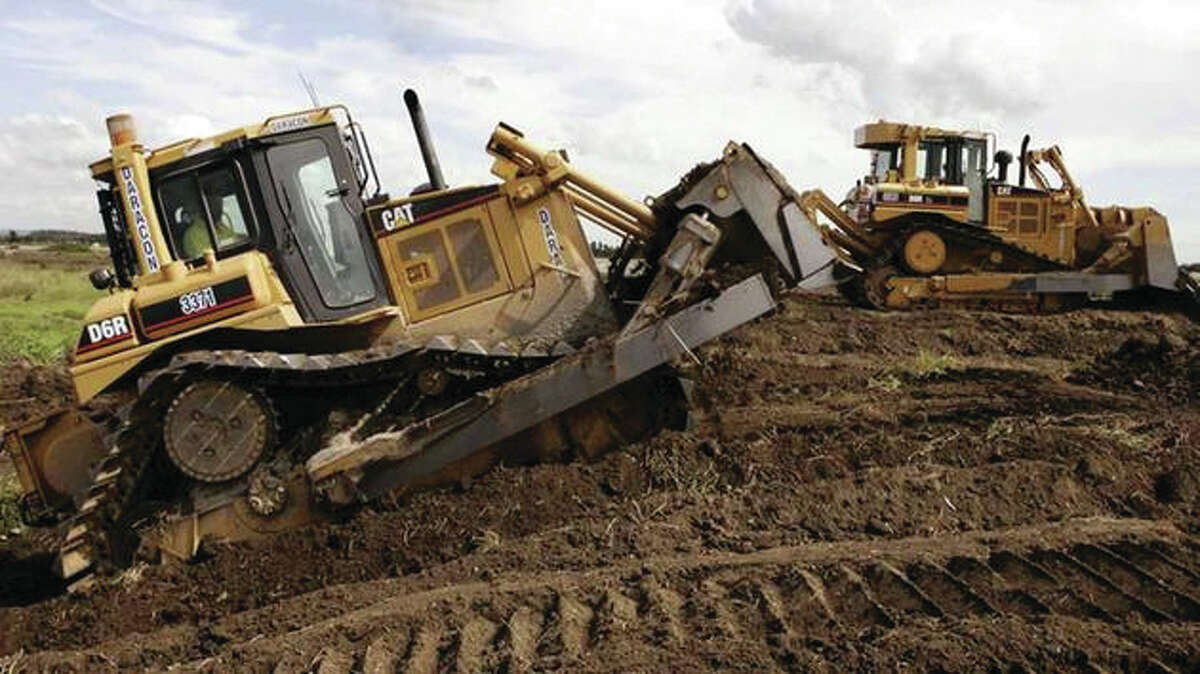 A pair of Caterpillar D6 bulldozers work on construction.