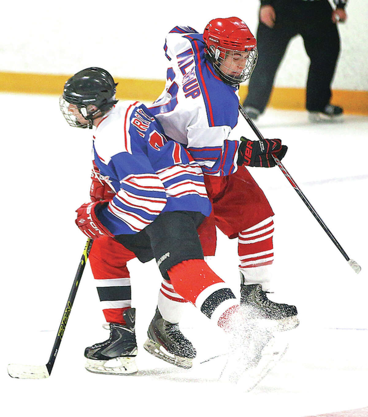 Alton’s Scotty Waldrup (back right) and Highland’s Brock Troxell collide at center ice Monday night during the MVCHA Class 1A All-Star Game at the East Alton Ice Arena.