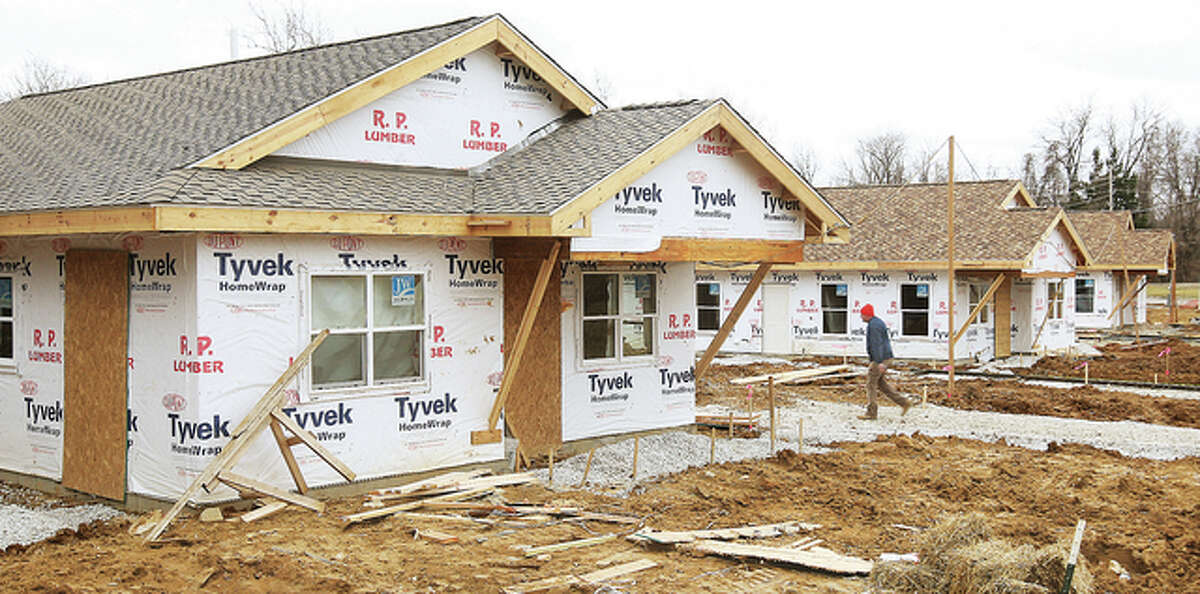 A worker walks back to one of several housing authority houses under construction on Toledo Avenue in Alton. Total construction in the city for 2014 included 593 building permits and $8,551,071 spent.