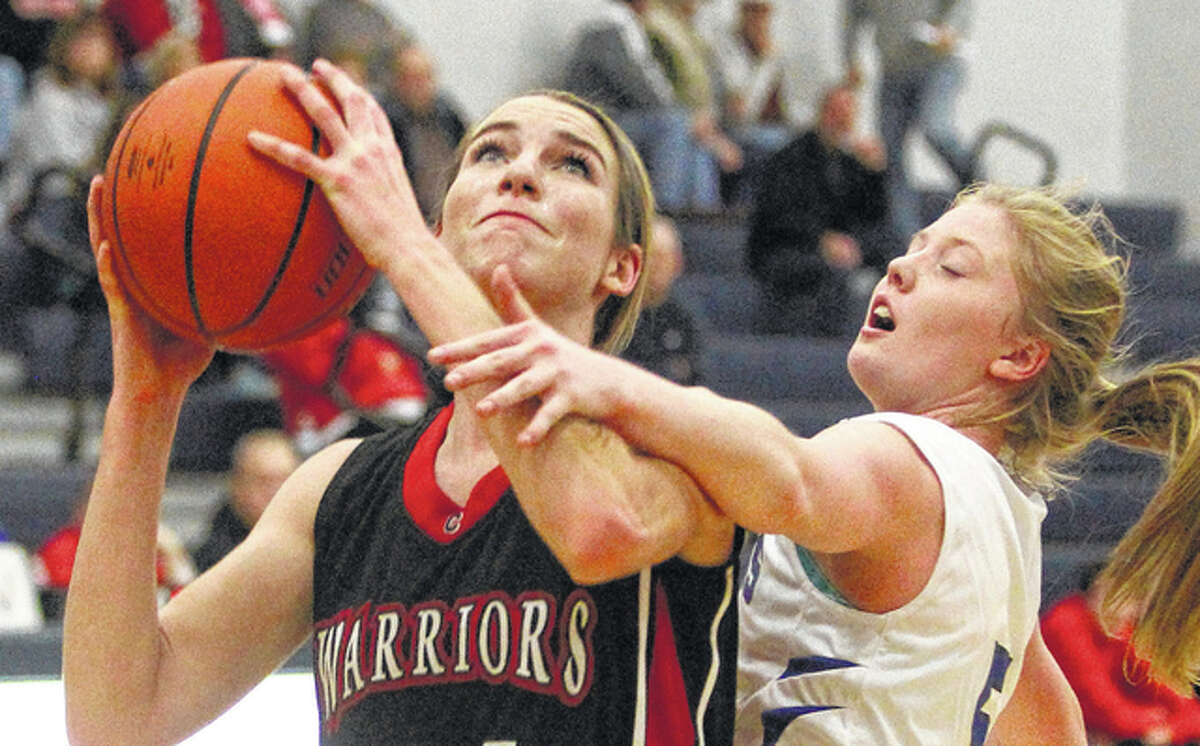 Calhoun junior Grace Baalman (left), shown going up for a shot past North Greene’s Bethany Randall in a game earlier this season in White Hall, scored 31 points Thursday night to lead the Warriors to a win over West Central in Hardin.