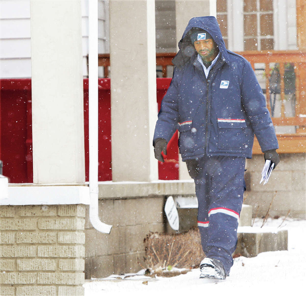 A conscientious Alton letter carrier makes his rounds in the snow, door-to-door, Tuesday on West 9th Street in Alton. Unfortunately, a substitue letter carrier in Alton recently did not share the same work ethic, dumping at least 200 pieces of mail in a ditch at Alby and Blair streets and in a dumpster elsewhere. The mail was scheduled to be delivered to a particular neighborhood on Jan. 23.