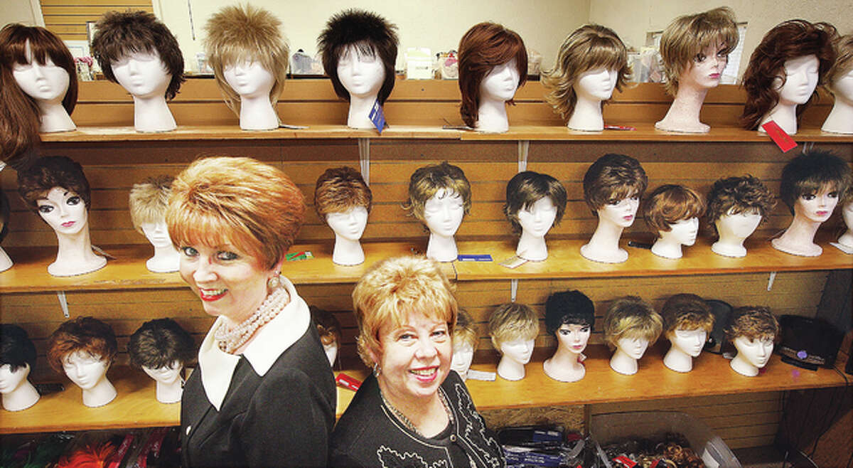 Carol Logan, left, new co-owner of Roberta’s Lovely Ladies Boutique, 603 W. Delmar in Alton, stands in front of the wig display with former owner Roberta Jaynes, right. Carol and Mike Logan now own the shop that largely helps women dealing with cancer related side effects.