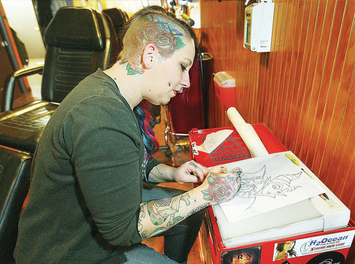 Tattoo artist Amanda Herren works on an original drawing this week at the Grand Piasa Body Art, which had a soft opening in its new location this week at the corner of E. Broadway and Henry Street in Alton. A grand opening is planned for the near future.