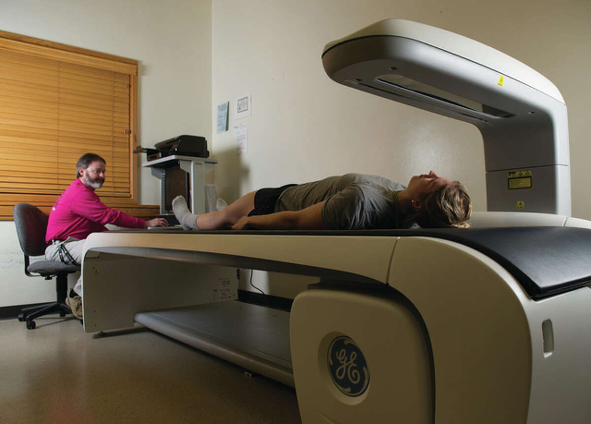Client Morgan Robertson undergoes a DEXA scan, monitored by Bryan Smith, PhD, assistant professor in the Department of Applied Health at SIUE. For The Telegraph