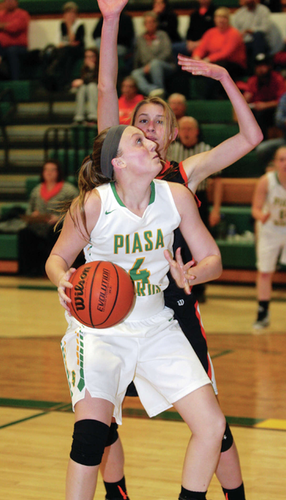 Southwestern’s Karlie Green (front) looks to the rim while being defended by Gillespie’s Abbie Barber during Thursday night’s Class 2A regional title game in Piasa.