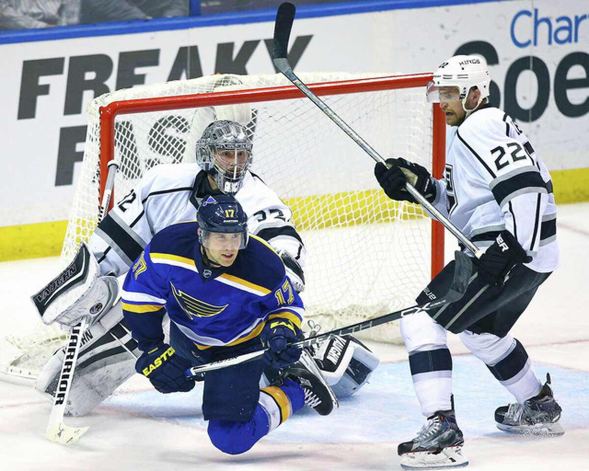 The Blues’ Jaden Schwartz (17) is tripped up by Los Angeles Kings center Trevor Lewis (22) as goalie Jonathan Quick looks for the puck in the third period of Thursday night’s game in St. Louis. The Blues won the game 2-1 in overtime.