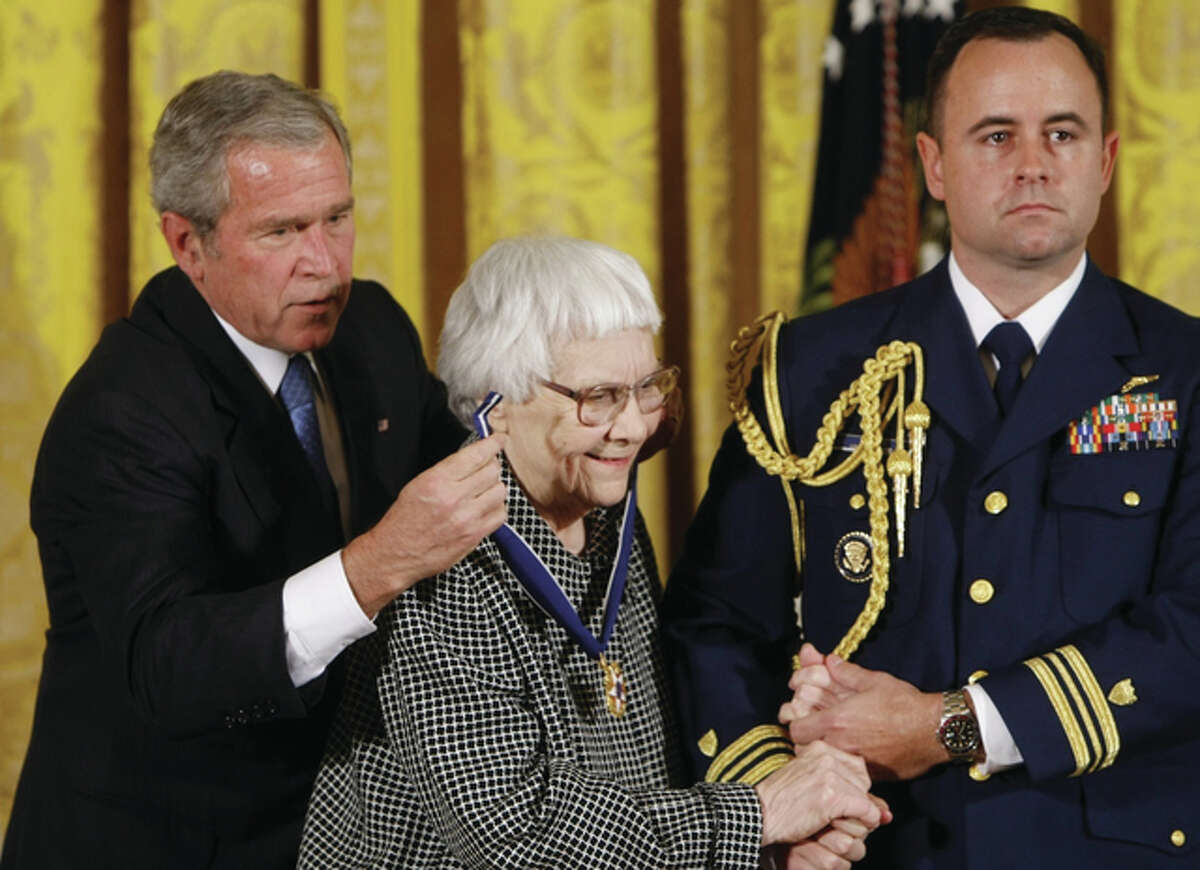 In this Nov. 5, 2007 file photo, President Bush, left, presents the Presidential Medal of Freedom to author Harper Lee, center, during a ceremony in the East Room of the White House in Washington. Lee, the elusive author of best-seller “To Kill a Mockingbird,” died Friday, Feb. 19, 2016, according to her publisher, Harper Collins. She was 89.