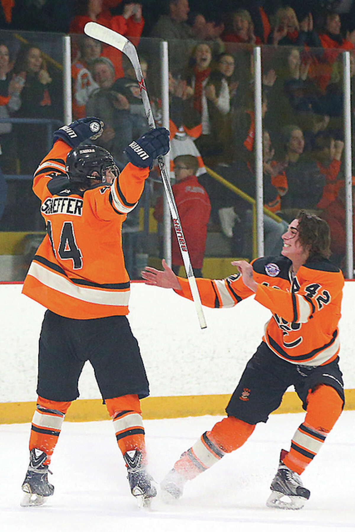 Edwardsville’s Tyler Schaeffer, left, celebrates with Jake Aurelio after scoring the game-winning goal in a shootout during Tuesday’s MVCHA 2A championship at East Alton Ice Arena. Edwardsville won the game 3-2 to secure their fifth straight MVCHA title.